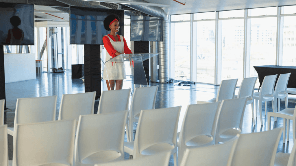 A professional Event Coordinator managing a meeting setup in a corporate environment